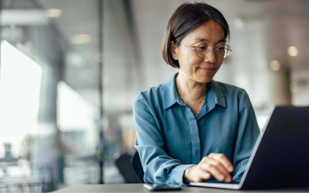 A female professional working on a laptop in an office environment