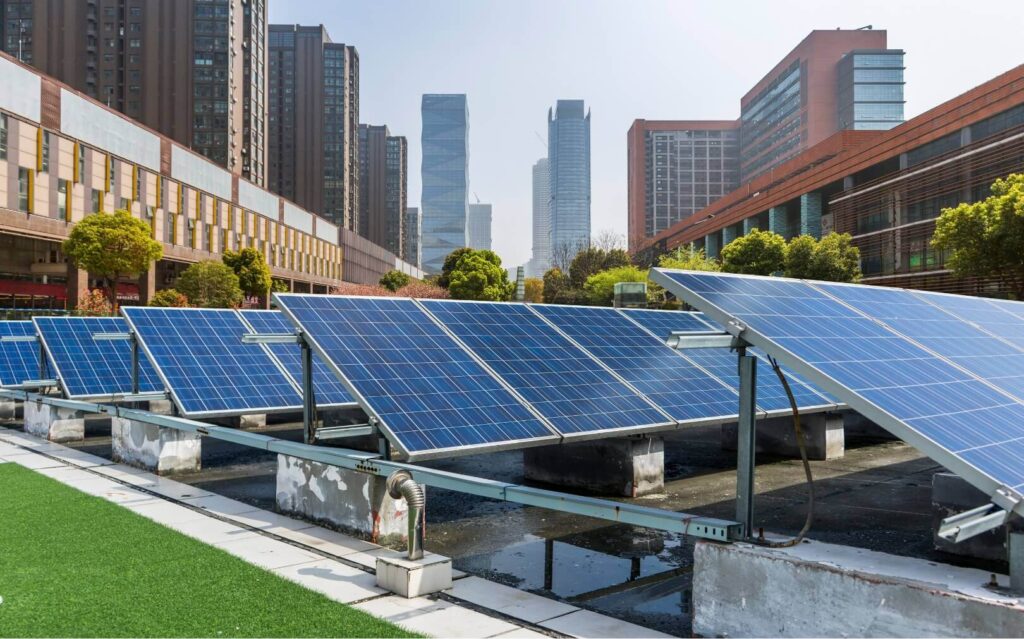 a row of solar panel arrays in the foreground of an urban environment with a city in the background