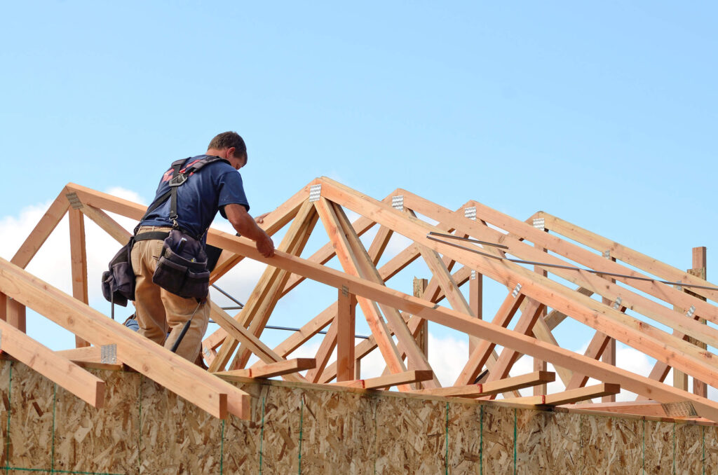 A construction worker is building a roof