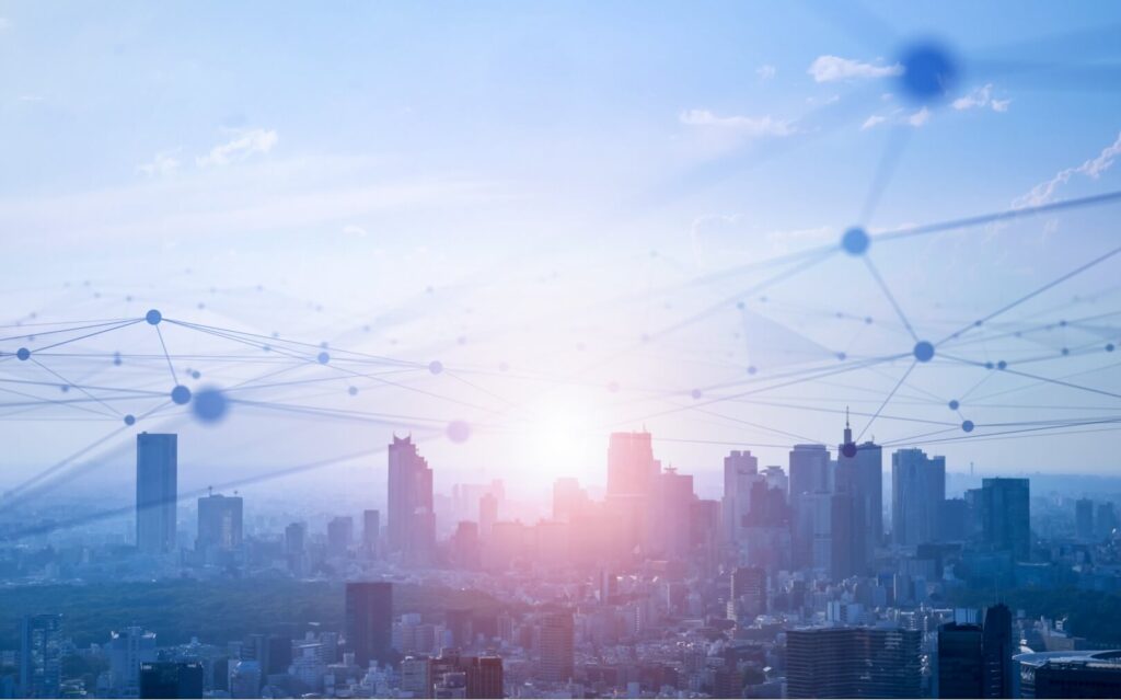 A conceptual image of a city skyline with a digital network overlay representing connectivity at sunrise