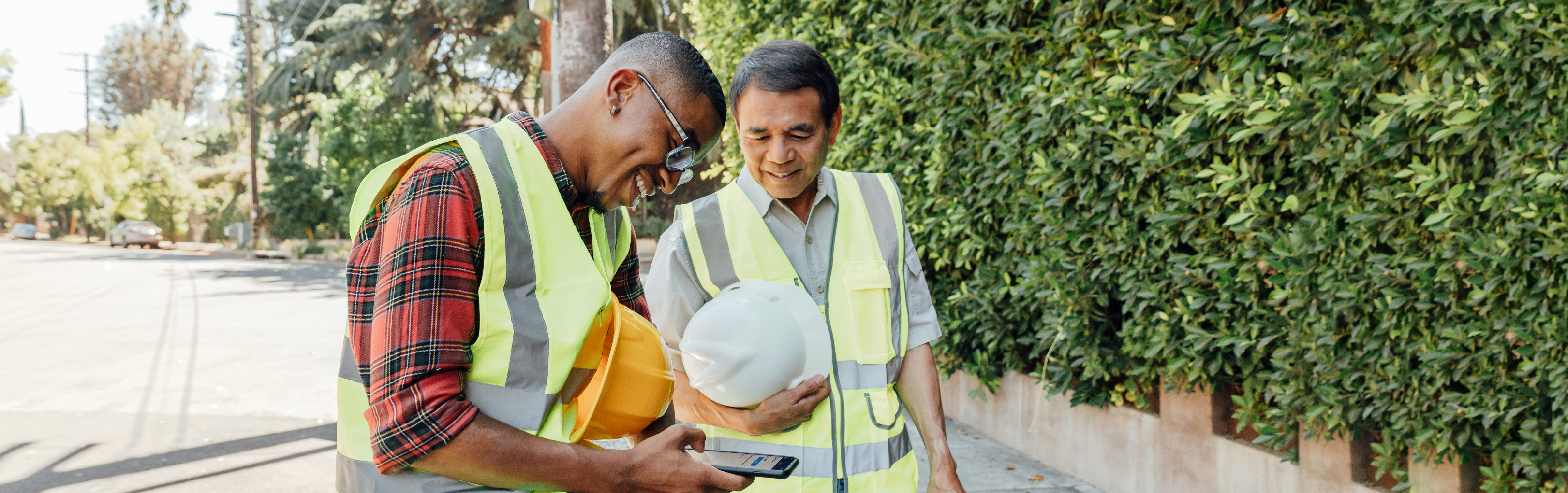 Two field workers looking at a mobile phone using Sitetracker