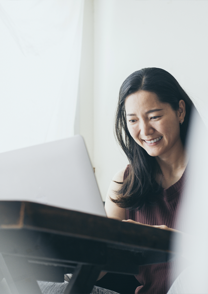 A female professional smiles at her laptop