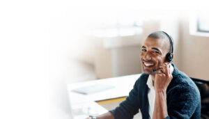 a male customer support specialist wearing a headset and smiling