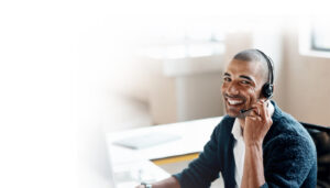 A customer service professional with a headset on smiling