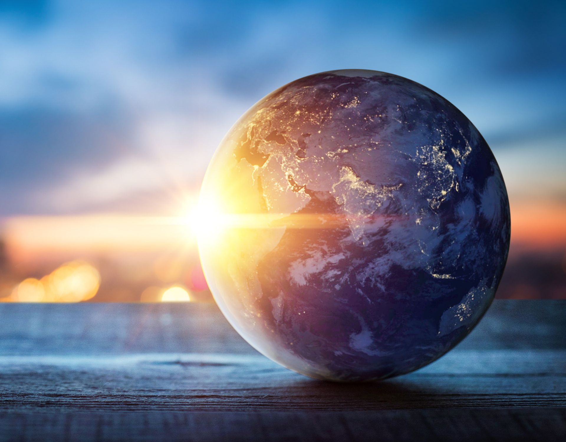 A globe sitting on a table with the sun behind it