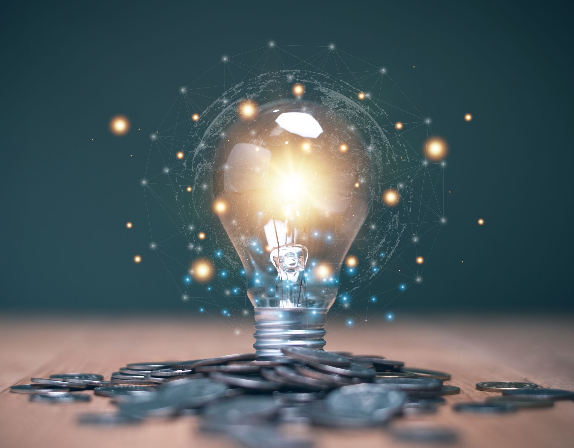 A glowing lightbulb on a table with coins surrounding the base