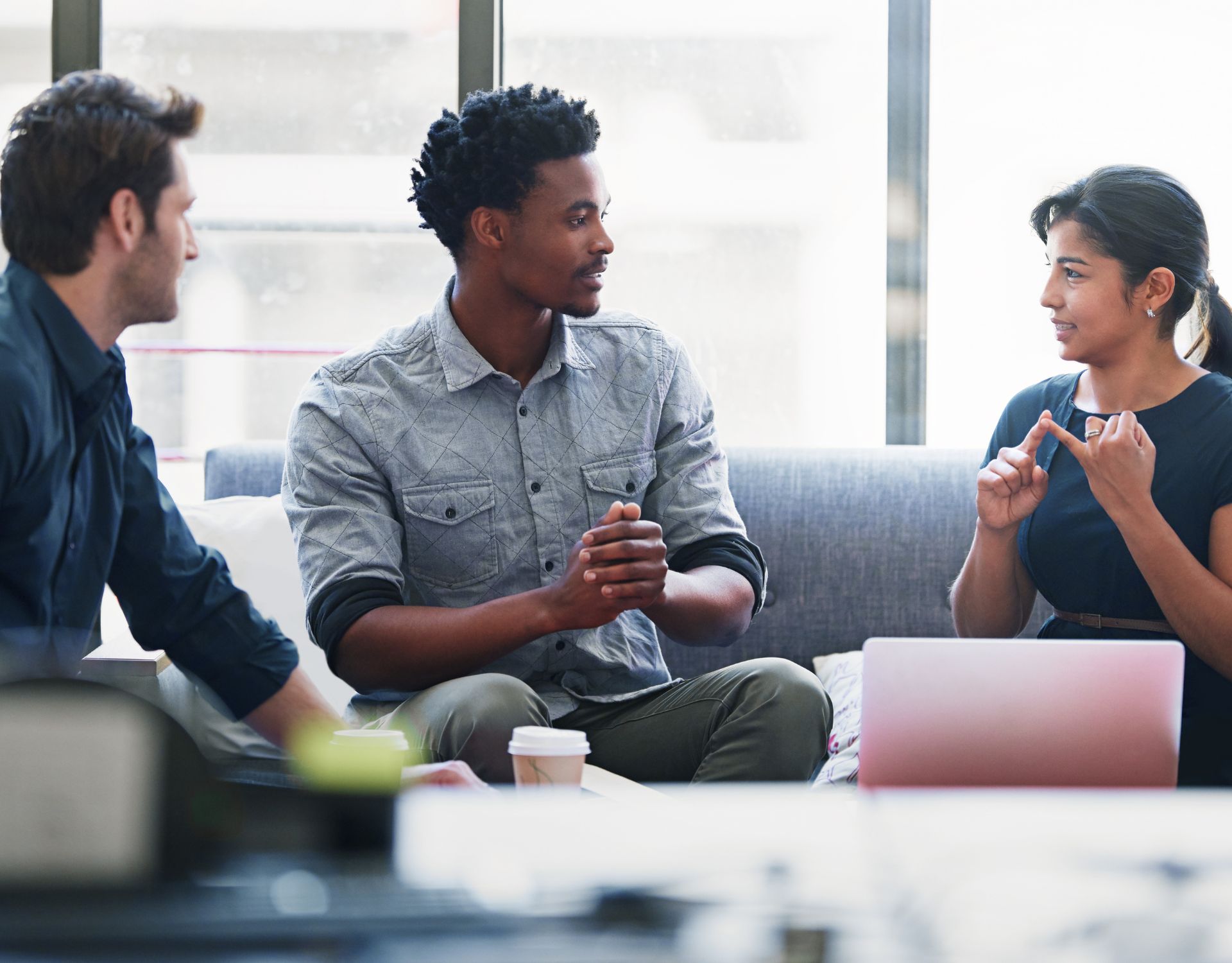 3 coworkers having a discussion on a couch