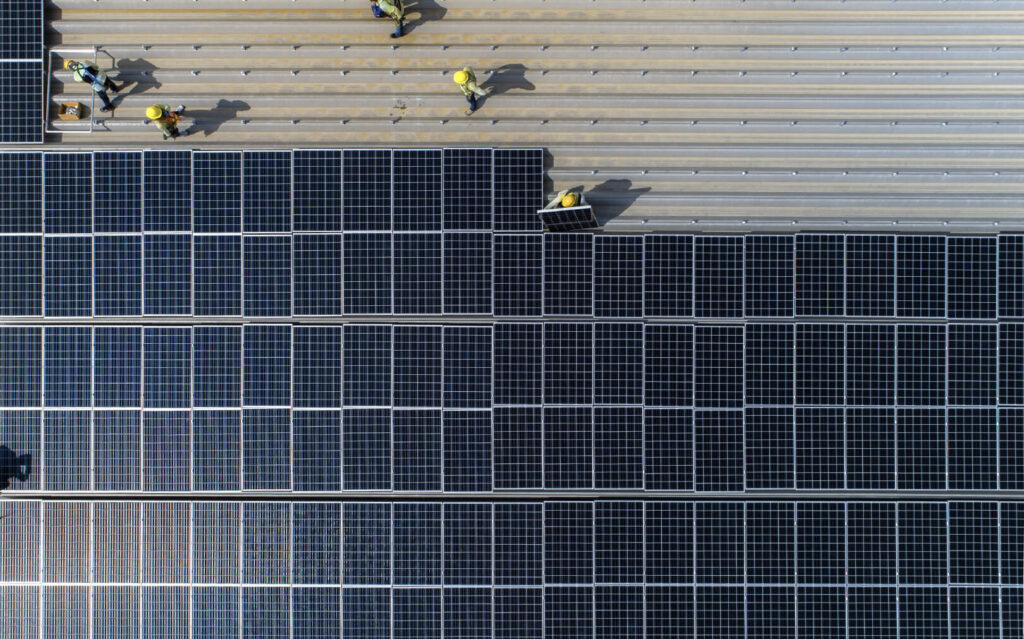 A aerial view of a team of solar technicians installing solar panels