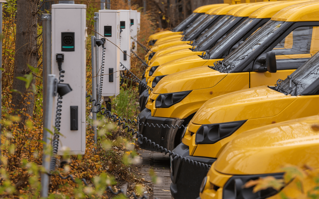 A fleet of yellow electric vehicles charging