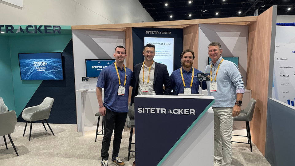 4 smiling Sitetracker employees stand in front of the event booth at Intersolar North America