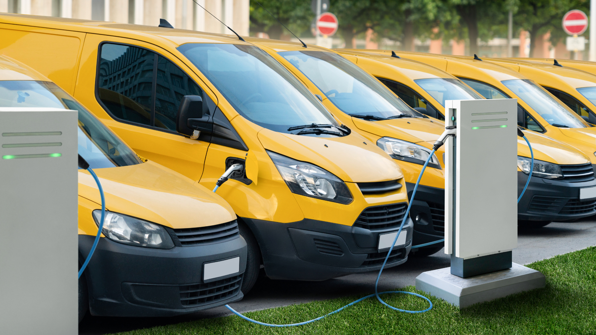 a fleet of yellow commercial electric vehicles charging