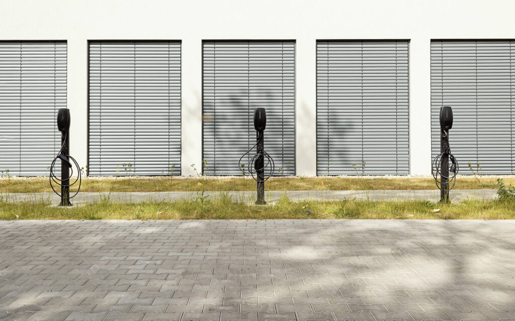 A row of black EV chargers in a parking lot