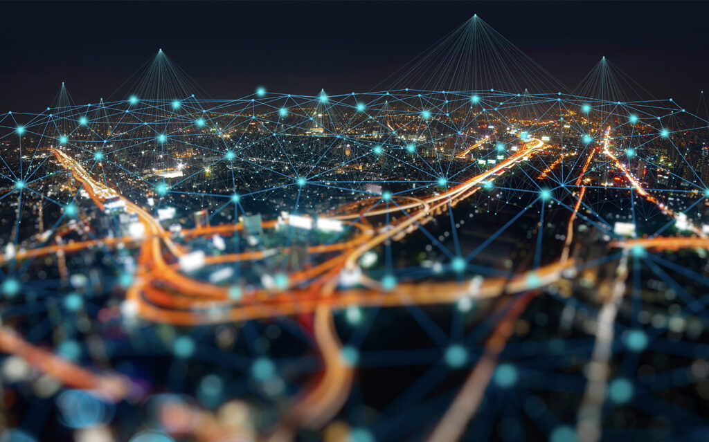 A conceptual image showing a cityscape at night with interconnected digital network lines and nodes overlaying the scene