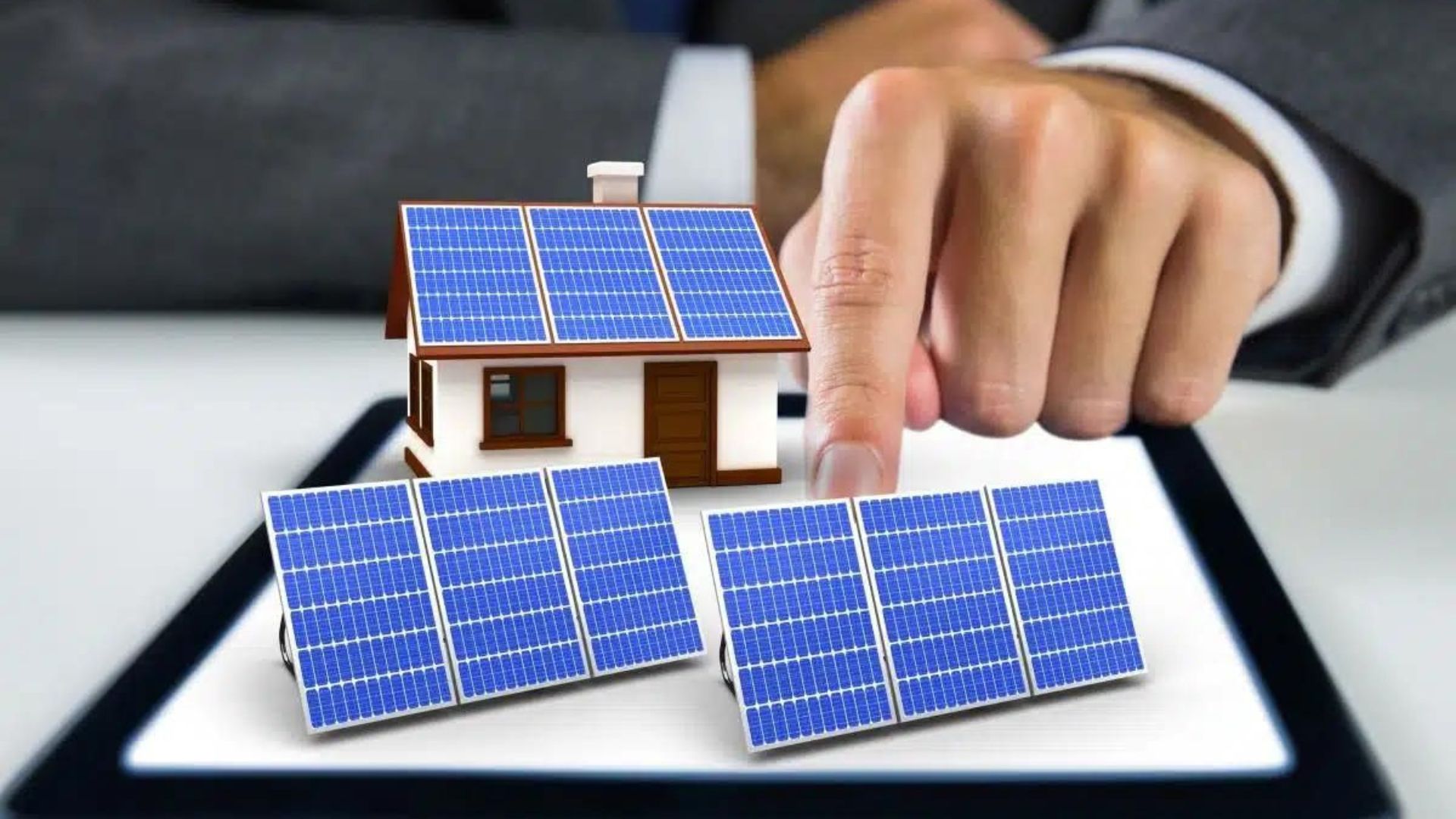 a hand moving around a small model home with solar panels