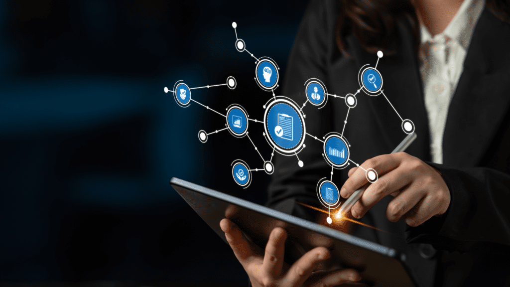 Business professional using a tablet with connected software and data icons floating above the screen