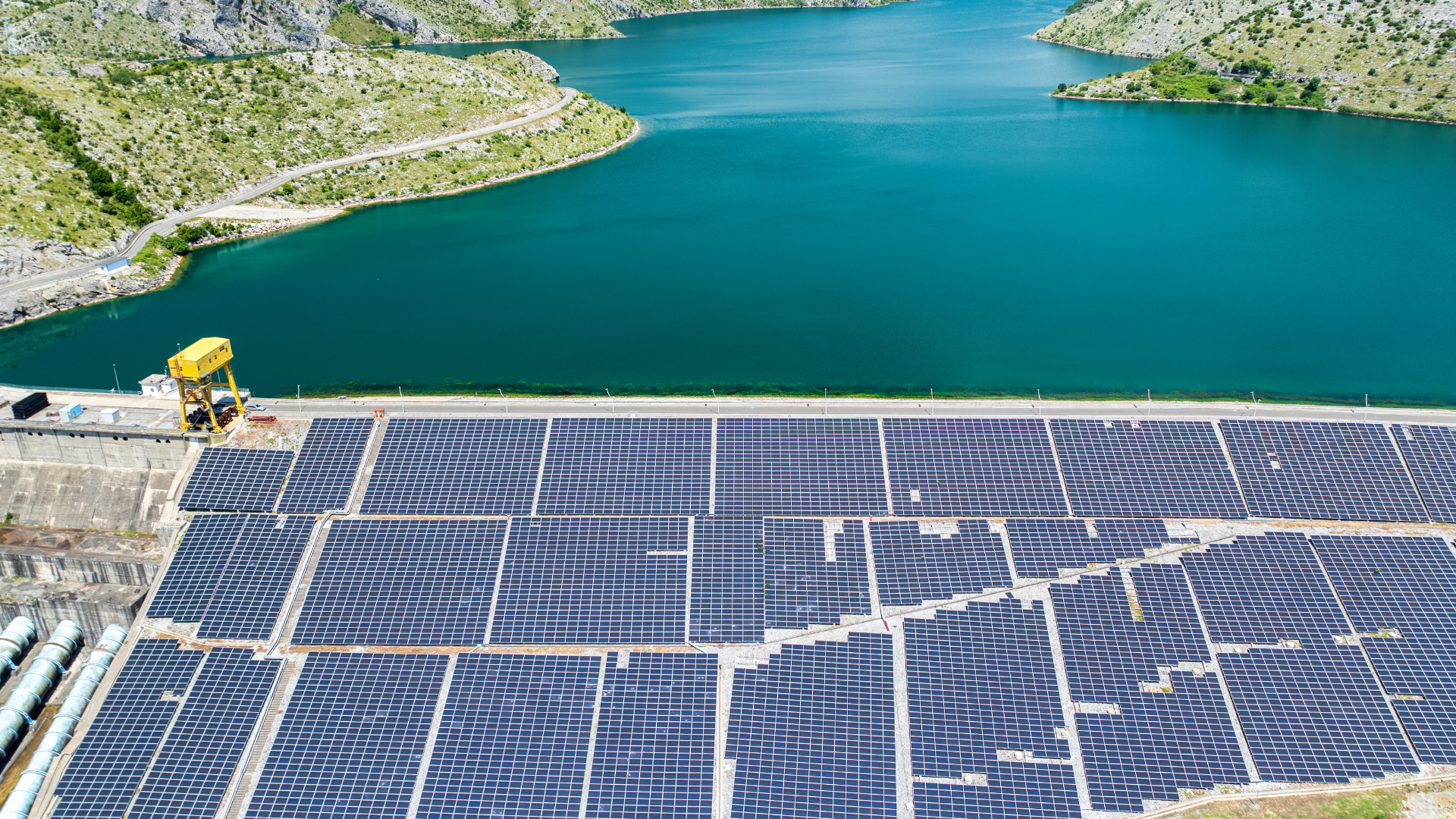 a field of solar panels near a large body of water