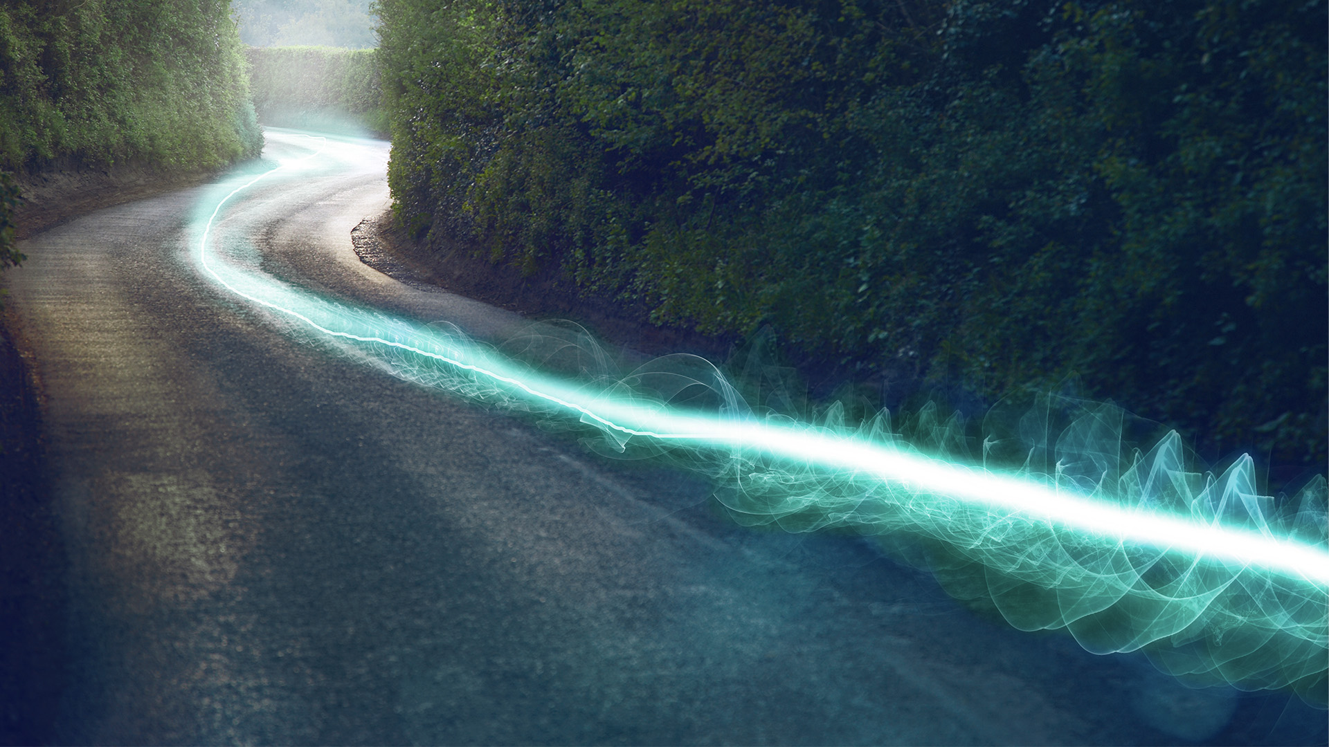 Winding road through dense greenery with a glowing blue digital line, representing high-speed fiber connectivity and expanding AI infrastructure